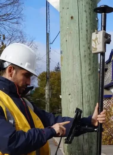 Surveyor working with a GNSS range pole and pole-mounted tablet