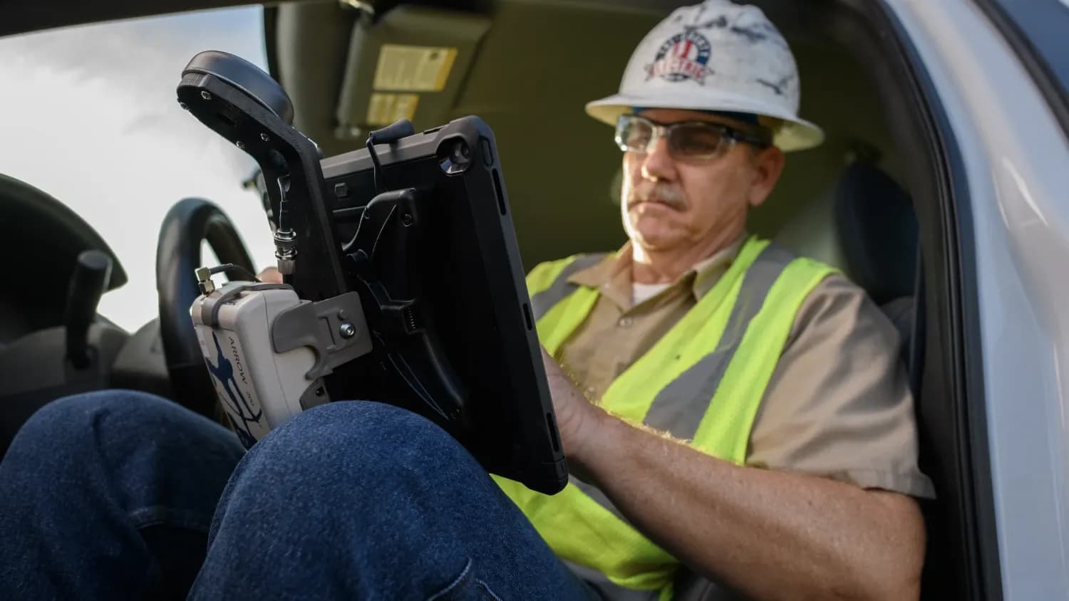 Field technician reviewing utility GIS data on a truck-mounted tablet with an Eos Arrow receiver